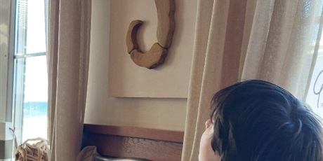 Powiększ grafikę: Chłopiec siedzi w restauracji, patrzy na obraz z konikiem morskim.