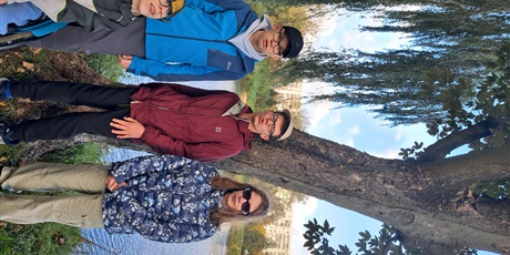 Powiększ grafikę: Czworo ucziów stoi pod drzewem.