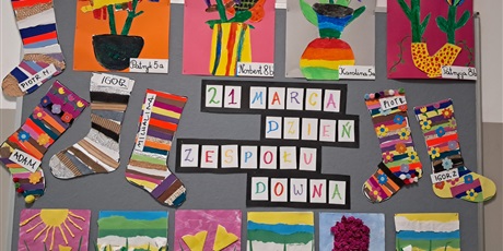 Powiększ grafikę: Tablica z napisem 21 marca Dzień Zespołu Downa i kolorowymi pracami  o tematyce wiosennej oraz skarpetkami nie do pary.