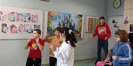 Powiększ grafikę: Dzieci tańczą na środku sali.