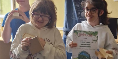 Powiększ grafikę: Dwóch chłopców i dwie dziewczynki stoją, trzymaja dyplom i drewniane pudełka.