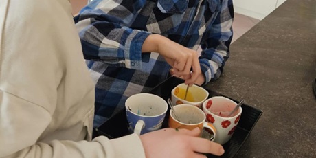 Powiększ grafikę: Dwóch chłopców rozrabia w kubeczkach barwniki.