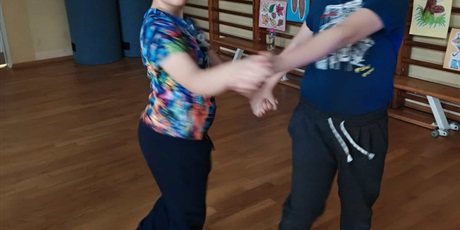 Powiększ grafikę: Dziewczynka i chłopiec tańczą trzymając sie za ręce.