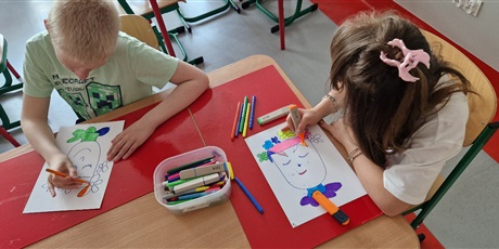 Powiększ grafikę: Dziewczynka i chłopiec siedza przy stoliku, kolorują mazakamy twarz z kwiatami na głowie.
