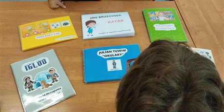 Powiększ grafikę: Na stoliku, przy którym siedzą dzieci leżą wykonane książki.