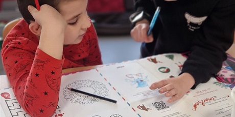 Powiększ grafikę: Dwóch chłopców zastanawia się jak wykonać zadania na macie z łamigłówkami.