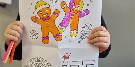 Powiększ grafikę: Chłopiec trzyma przed sobą pokolorowany rysunek, jest zadowolony.