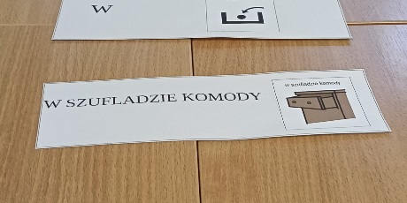 Powiększ grafikę: Polecenie ułożone z etykiet na ławce.