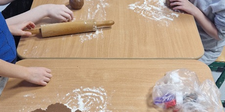 Powiększ grafikę: Uczniowie wałkują ciasto na pierniki.