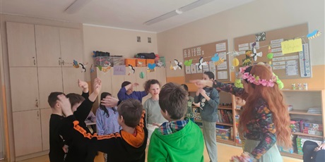 Powiększ grafikę: Uczniowie tańczą w kole powtarzając gesty nauczycielki.