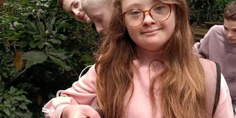 Powiększ grafikę: Uczniowie stoją w rzędzie przy barierce.