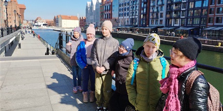 Powiększ grafikę: Sześcioro uczniów stoi w szeregu przy balustradzie nad Motławą. W tle widać Żuraw gdański.