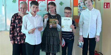 Powiększ grafikę: Grupa uczniów z nauczycielką prezentuje dyplomy.