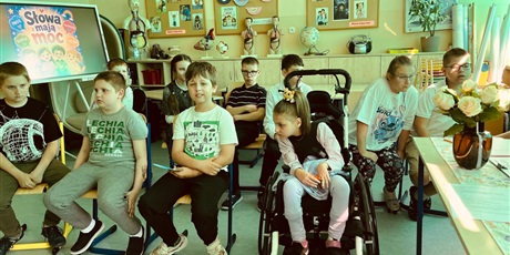 Powiększ grafikę: Grupa młodszych dzieci biorących udział w konkursie siedzi w klasie.