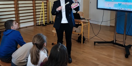 Powiększ grafikę: Kobieta prezentuje na modelu jak należy myć zęby.