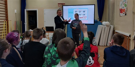 Powiększ grafikę: Kobieta prezentuje dziewczynce jak należy myć ręce.