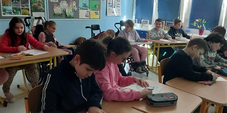 Powiększ grafikę: Uczniowie siedzą w ławkach i uzupełniają karty pracy.