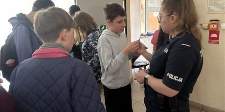 Powiększ grafikę: Grupa uczniów z panią policjantką.