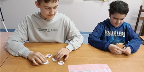 Powiększ grafikę: Uczniowie oglądają piktogramy.