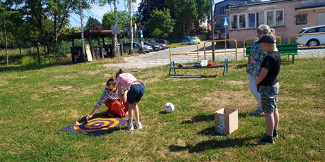 Powiększ grafikę: Chłopiec i dziewczynka oglądają tarczę rozłożoną na trawie, obok leży piłka. 