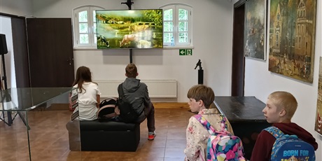 Powiększ grafikę: Uczniowie oglądają film w sali muzeum.