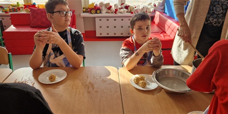 Powiększ grafikę: Uczniowie układają ulepione kulki na talerzykach.