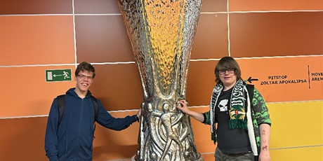 Powiększ grafikę: Uczniowie stoją przy pucharze UEFA.