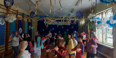 Powiększ grafikę: Dzieci tańczą w udekorowanej balonami i złotymi serpentynami sali.  